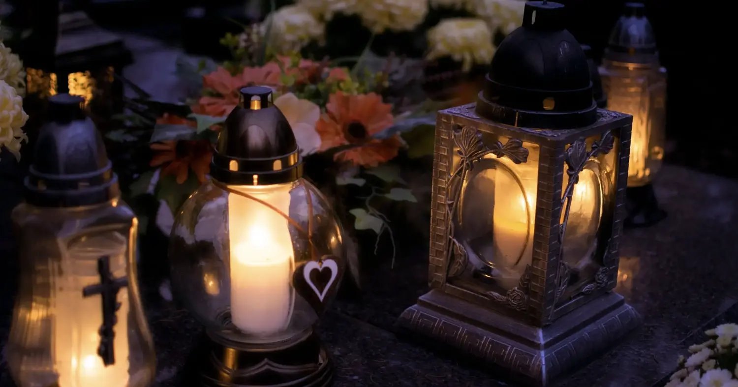 Brandende gedenklichtjes en lantaarns tussen bloemen op een graf